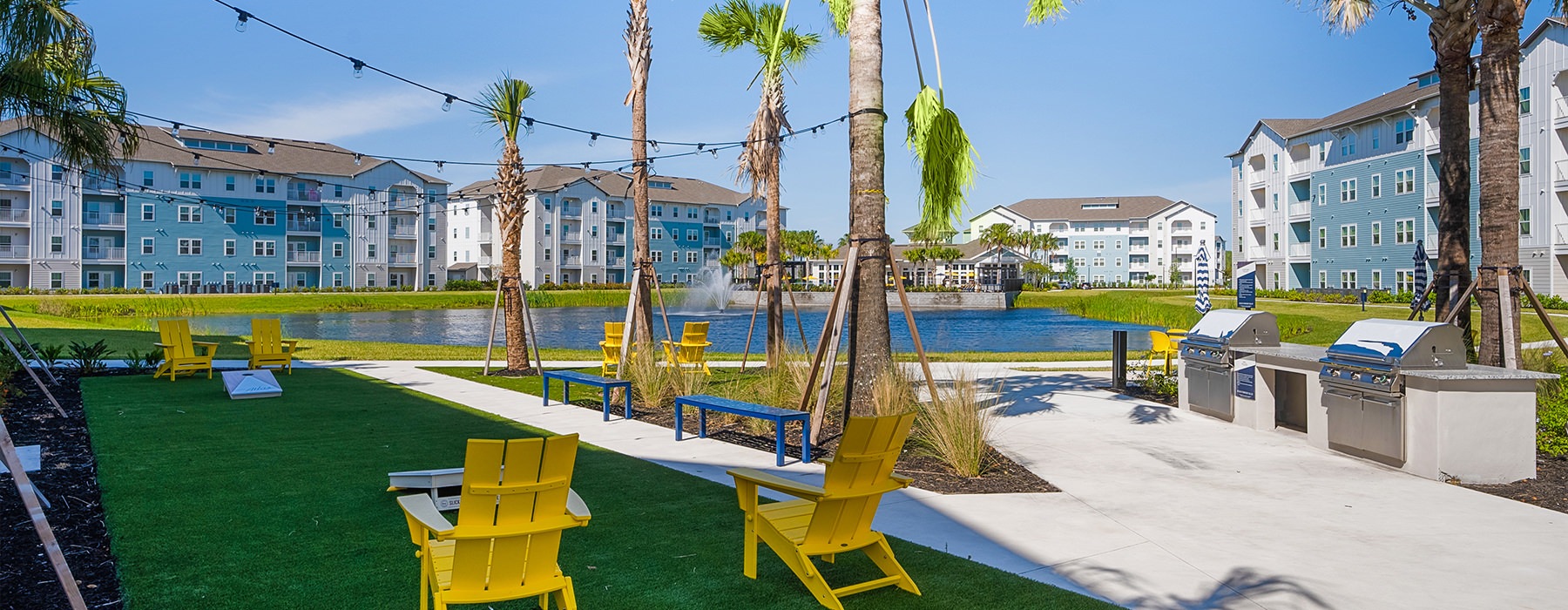 a lawn with chairs and palm trees